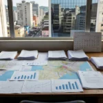 Mesa com mapas e gráficos de sazonalidade no mercado imobiliário brasileiro