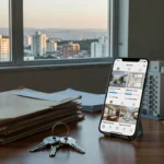 Mesa de escritório imobiliário com smartphone exibindo stories de processos de venda de imóveis no Brasil