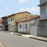 Rua residencial brasileira com imóveis à venda de imobiliárias concorrentes