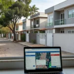 Rua residencial brasileira com notebook mostrando alertas de imóveis para corretores