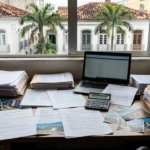 Mesa com documentos e fotos de imóveis para cálculo de tempo médio de exclusividade na carteira imobiliária